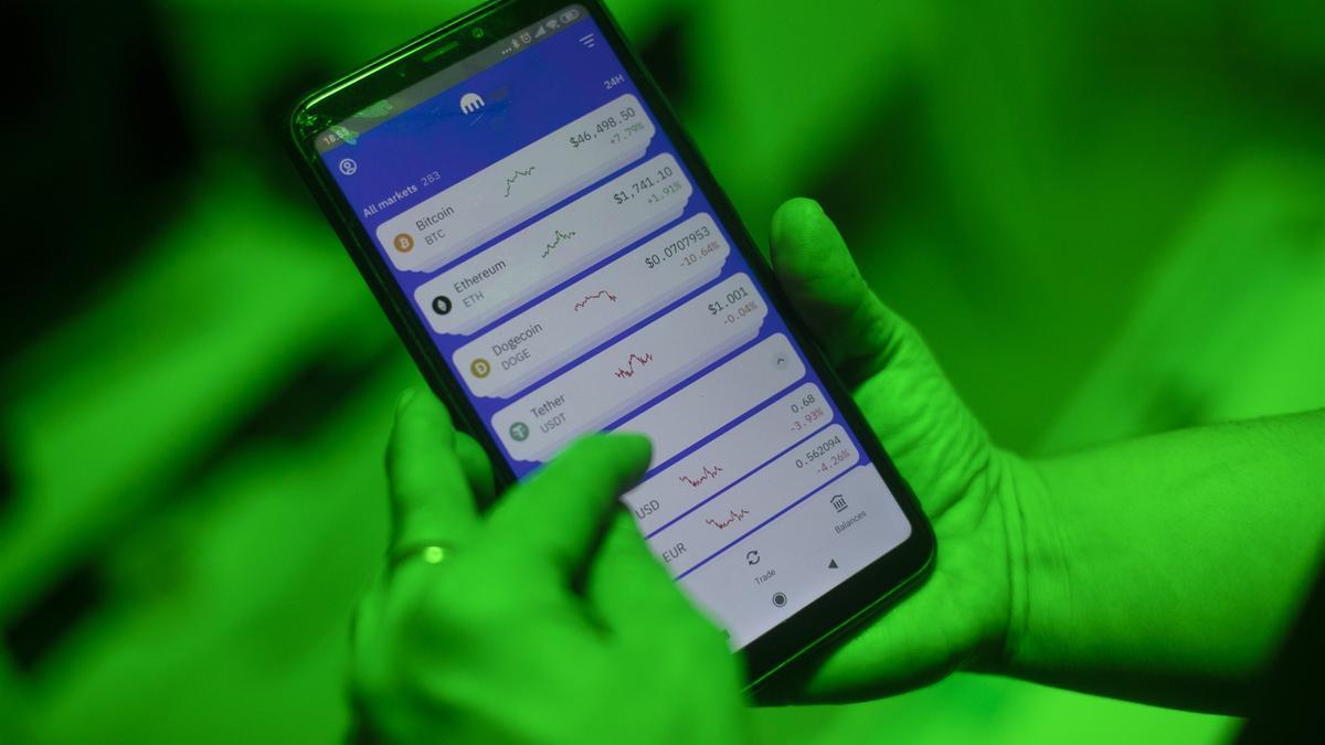 Archivo - Una internauta utiliza la aplicación Kraken para invertir en criptomonedas, en Madrid (España).