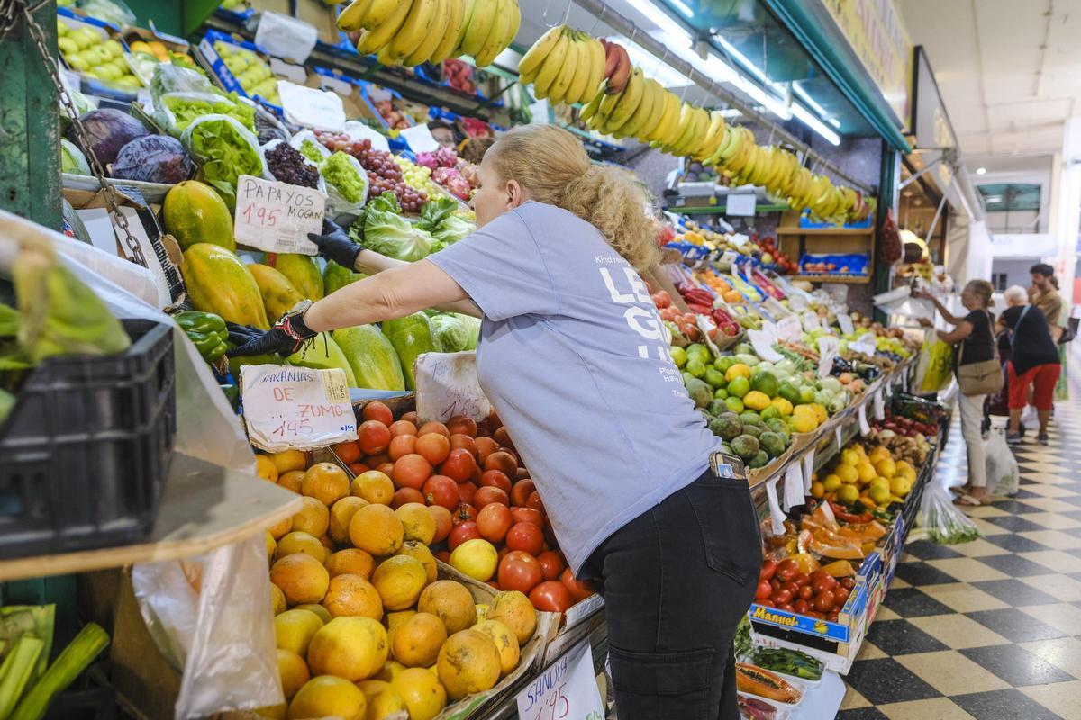 Una vendedora organiza su puesto de frutas y verduras del Mercado Central, en la capital grancanaria.