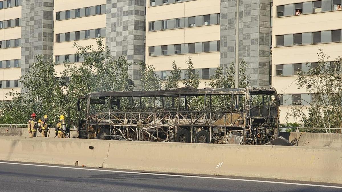Restos del autocar incendiado en la C-31 entre Badalona y Sant Adrià de Besòs.