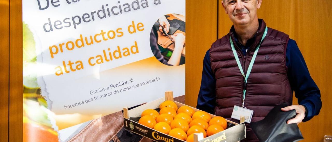 Jaime Sanfélix, ayer con una caja de caquis en una mano y el cuero en la otra. | LEVANTE-EMV