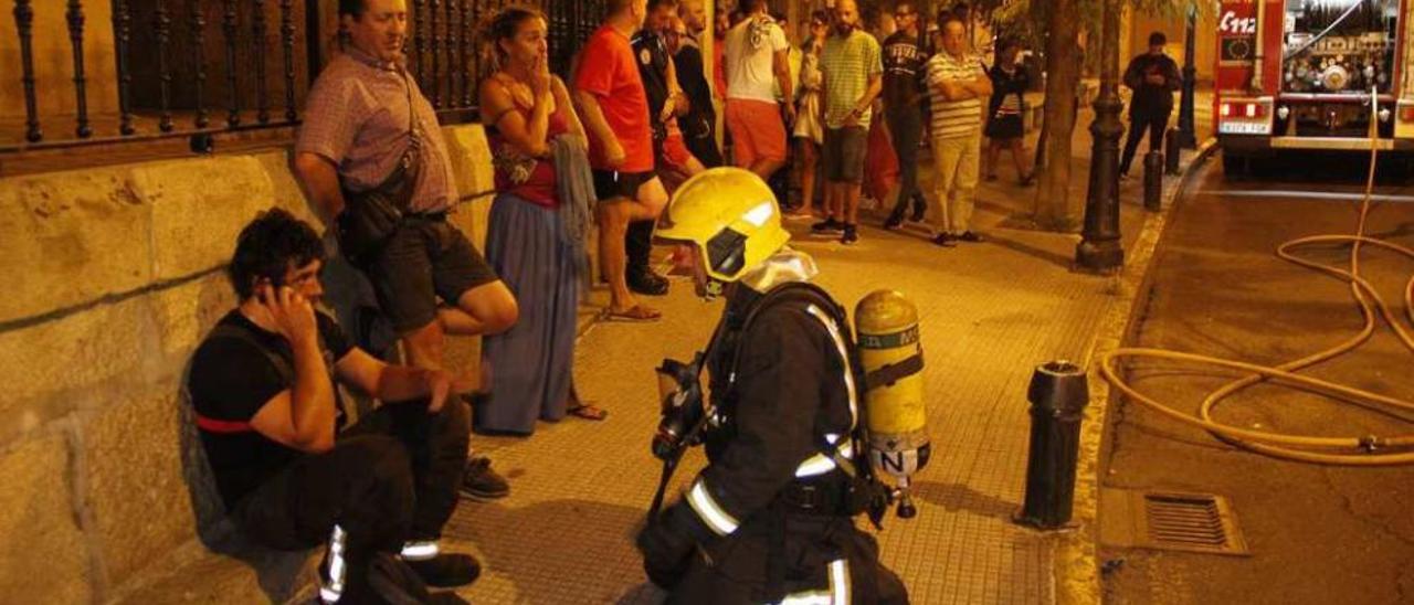 Los bomberos y vecinos durante las labores de extinción del incendio. // Santos Álvarez