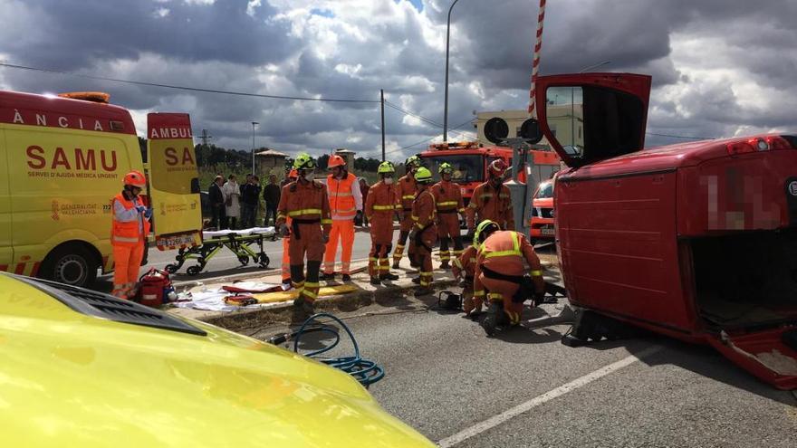 Los bomberos rescatan al conductor de la furgoneta atrapado tras el vuelco.