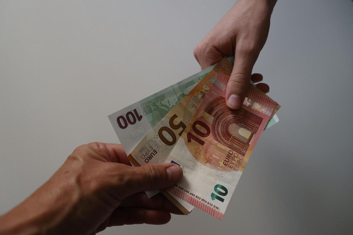 Foto de archivo de unos billetes de euro en las manos.