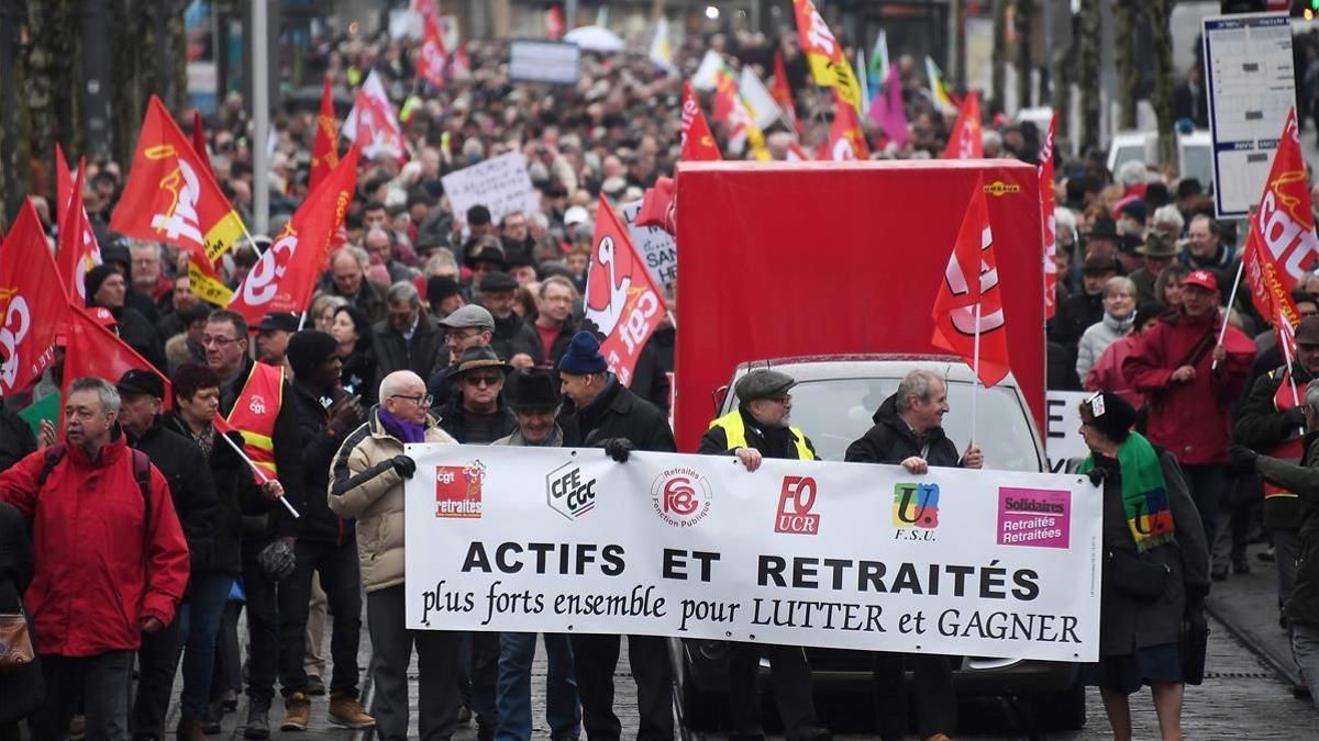 Manifestantes con una pancarta que alude a la lucha conjunta de jubilados y trabajadores, en Estrasburgo, el 15 de marzo.