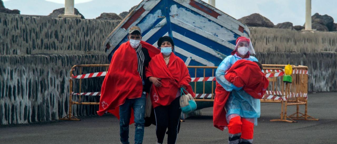 Una asistente en tierra lleva en brazos a un bebé junto a una pareja, ayer, en el muelle en Lanzarote.