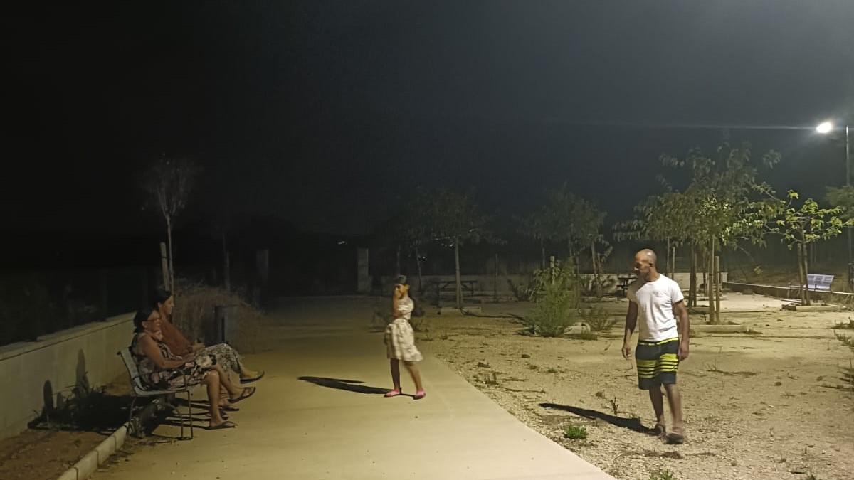 Una familia realiza una visita nocturna a uno de los parques, ahora iluminados, de la urbanización de l'Énova.