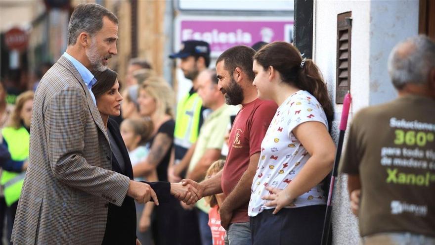 Un voluntario de Sant Llorenç le ofrece al Rey una escoba para que barra