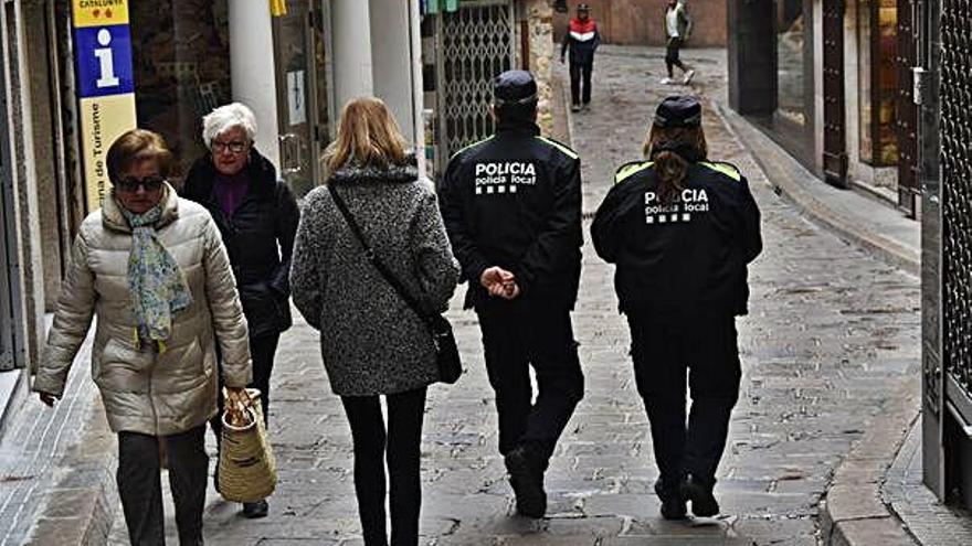 Dos agents de la Policia Local de Berga caminant entre la gent en una patrulla a peu per la ciutat