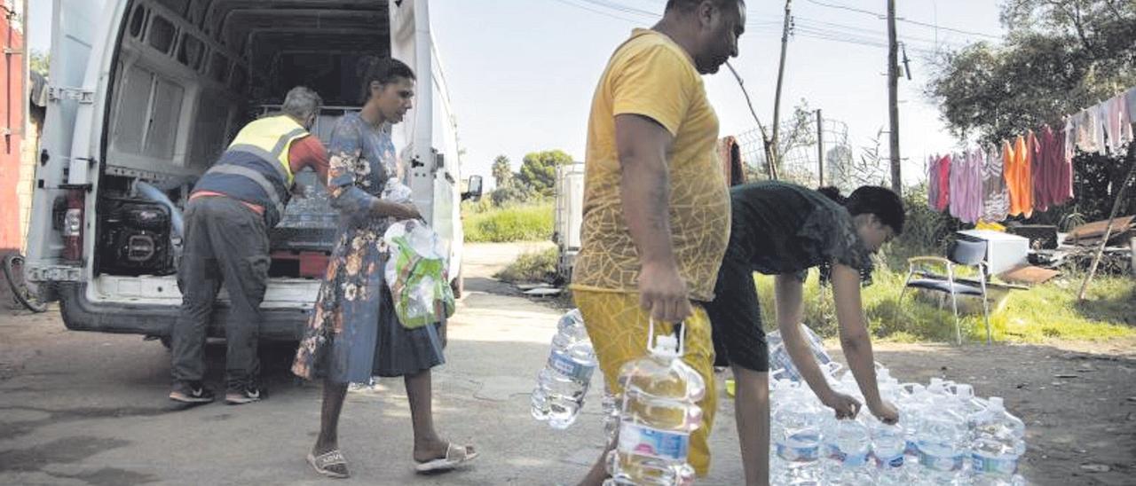 Reparto de agua embotellada donada por una empresa en el asentamiento denominado Oceanogràfic 50