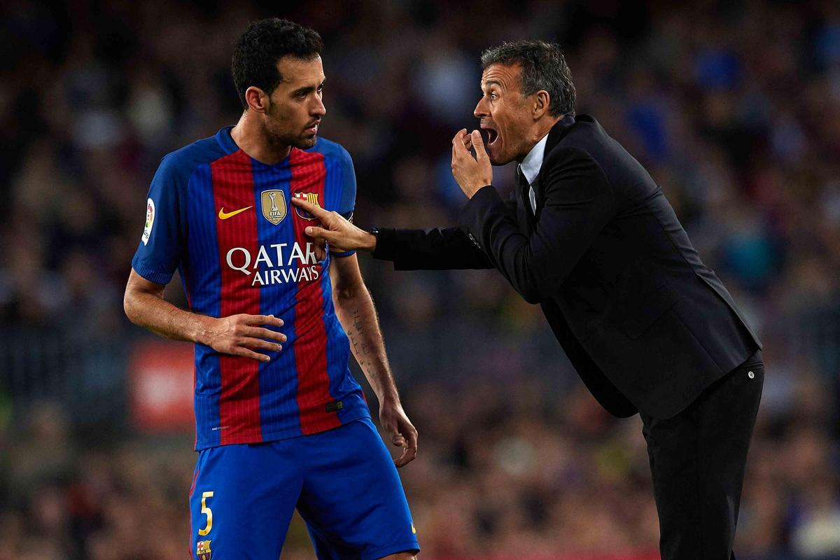 Luis Enrique, charlando con Sergio Busquets durante un partido con el Barça