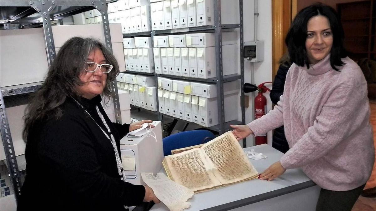 Maite López Carrillo y Ana Lazo muestran uno de los documentos del archivo municipal de Rute.