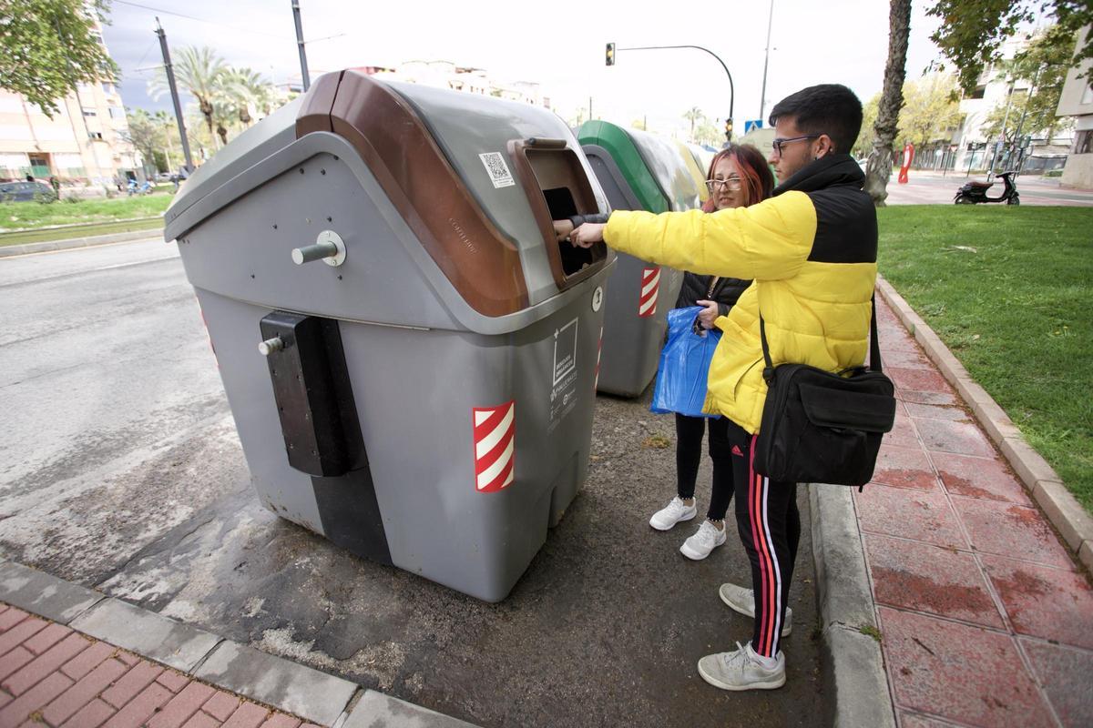 Unos vecinos de Murcia tirán residuos orgánicos en el contenedor marrón.