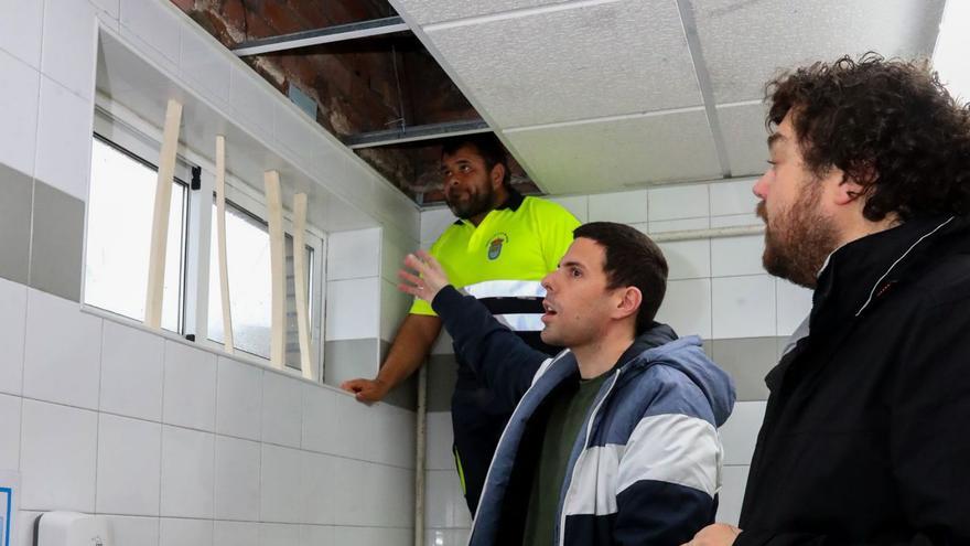 Un operario municipalk trata de reparar el dintel de una ventana ante el alcalde y Julio Torrado.