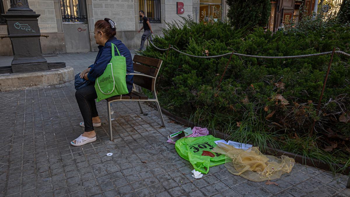 Una mujer se toma un respiro junto a una pequeña montañita de basura, en la supermanzana de Sant Antoni