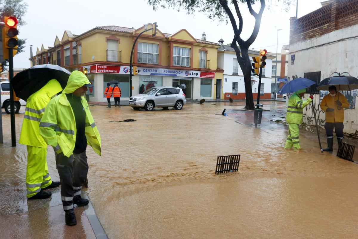 MLG (Campanillas) 31-03-2020.-Operarios de los servicios operativos ayudan a retirar el exceso de agua acumulada en la barriada de Campanillas tras el desbordamiento del río a cusa de las fuertes lluvias caída la pasada madrugada.-ÁLEX ZEA