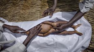 El imán de una mezquita en Chad prepara el cadáver de un niño para su funeral.