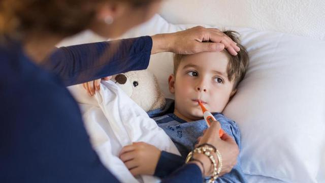 Madre toma la fiebre a su hijo