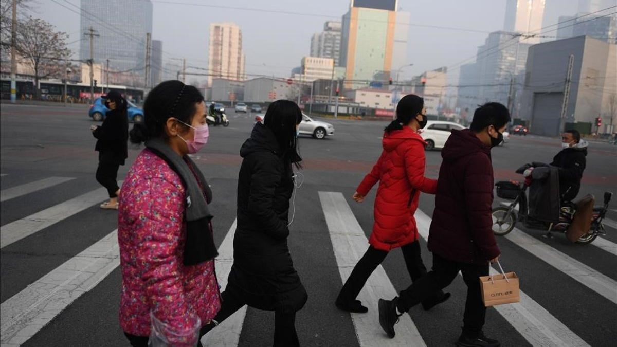 Calle concurrida en Beijing, con ciudadanos protegidos con máscaras por miedo al contagio por coronavirus