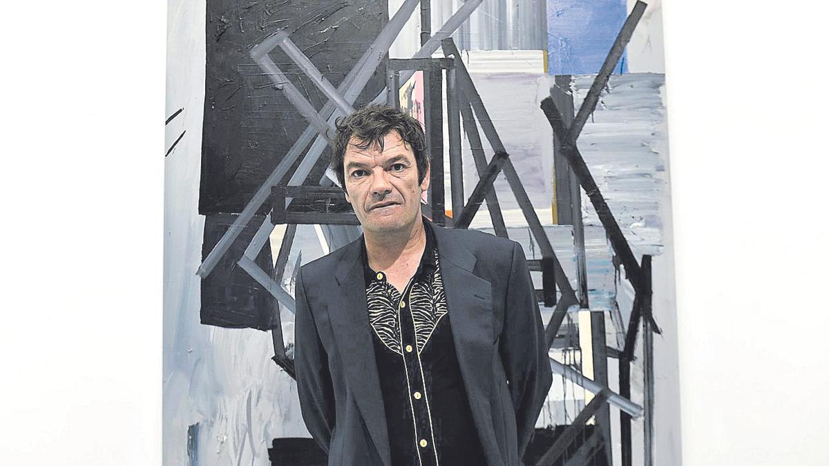 El artista, Miguel Fructuoso, posando con una de las obras