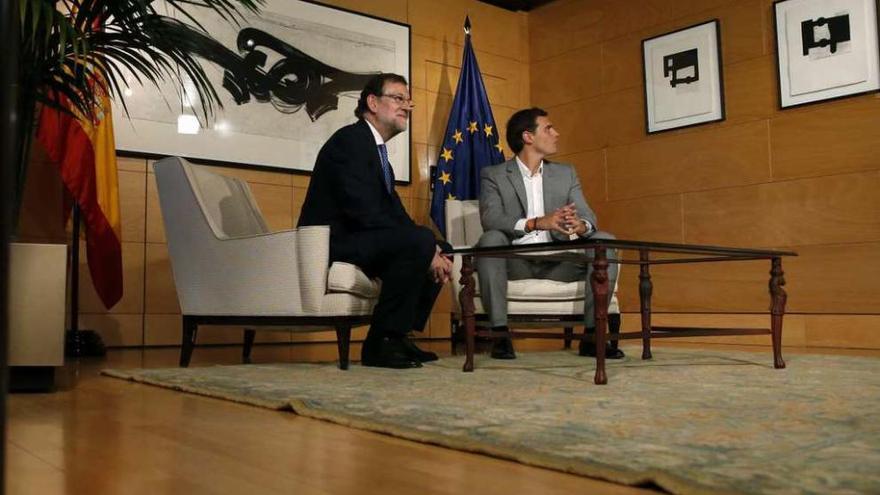 Rajoy y Rivera, ayer, esperando a que los fotógrafos terminaran su trabajo. A la derecha, los líderes del PP y de Podemos, en la entrevista.  // Efe