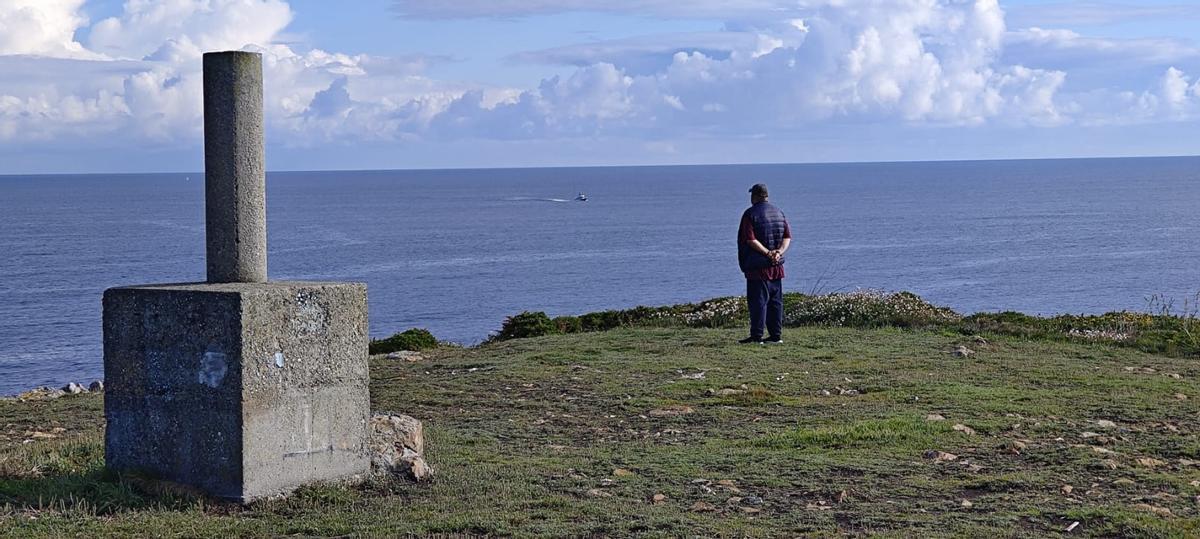 Un viandante observa el mar, con la patrullera de la Guardia Civil al fondo.
