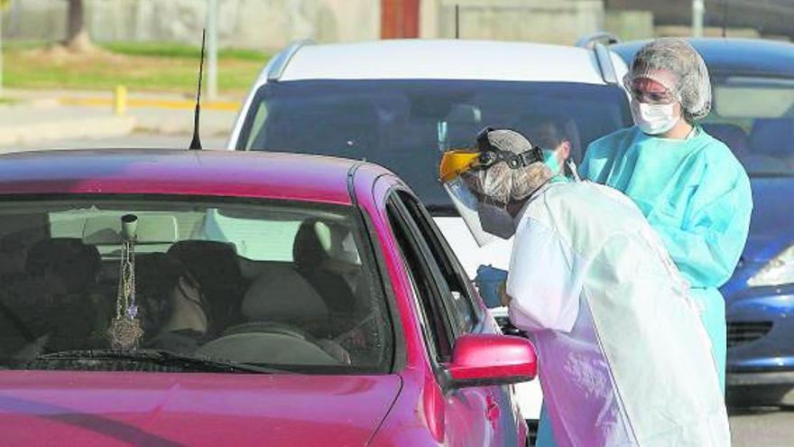 Dos sanitarias realizan una prueba PCR a una persona, en el exterior del hospital de Sant Joan.