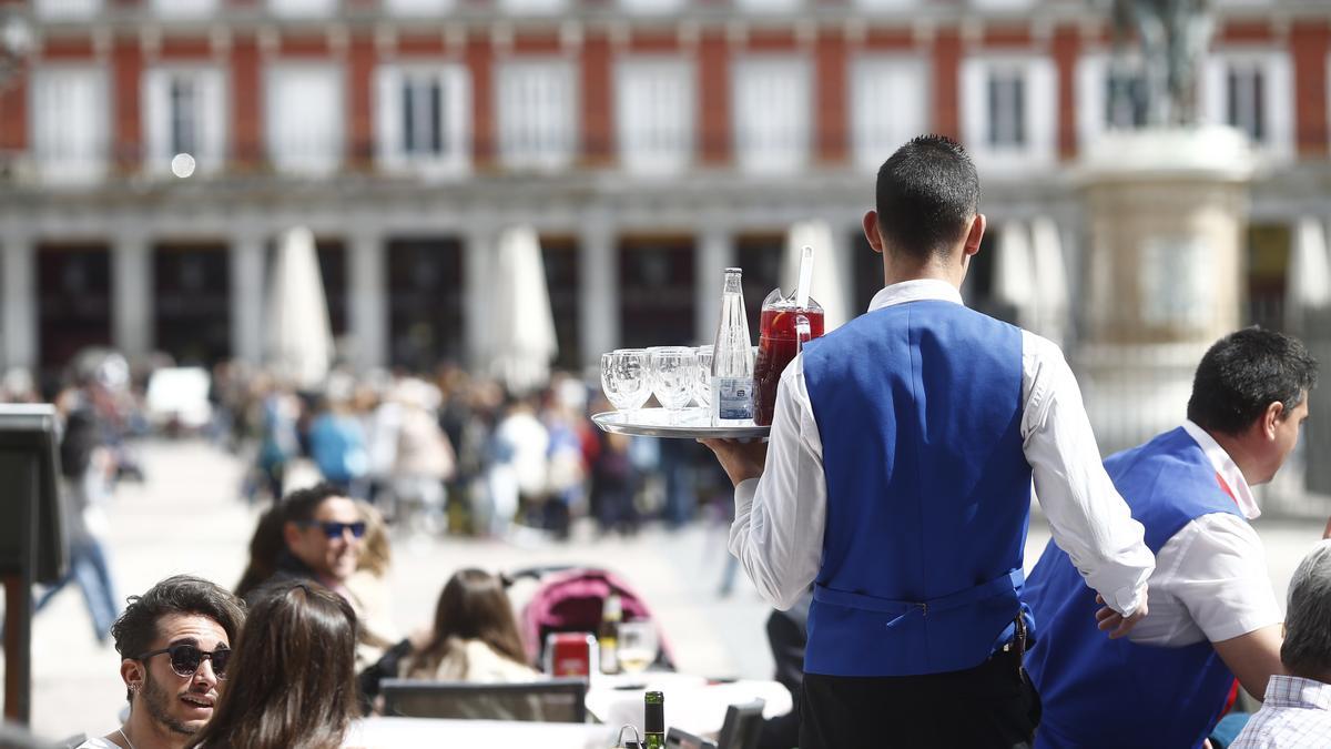 Un camarero trabaja en una terraza en la Plaza Mayor de Madrid.