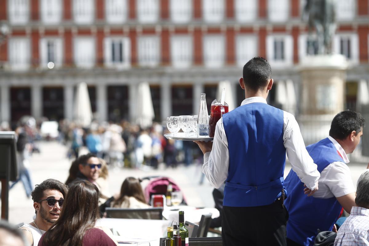 Un camarero atiende a los clientes de una terraza en la Plaza Mayor de Madrid