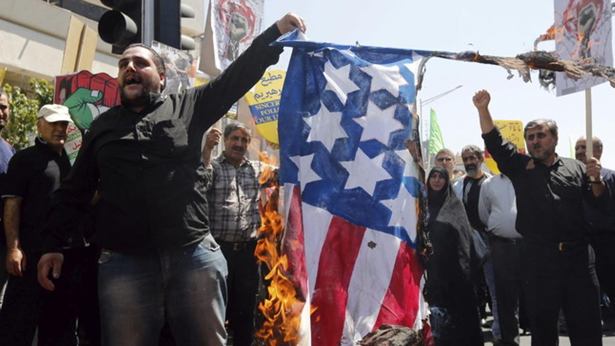 Manifestantes iranís queman una bandera estadounidense mientras piden la liberación de Palestina.