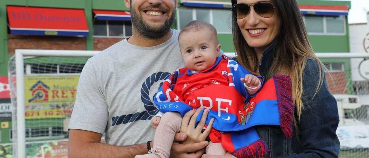 La abonada más joven de la UD Ourense, Aldara Matas Rodríguez, en brazos de sus padres, Eva y José Ángel, ayer en O Couto. // Jesús Regal