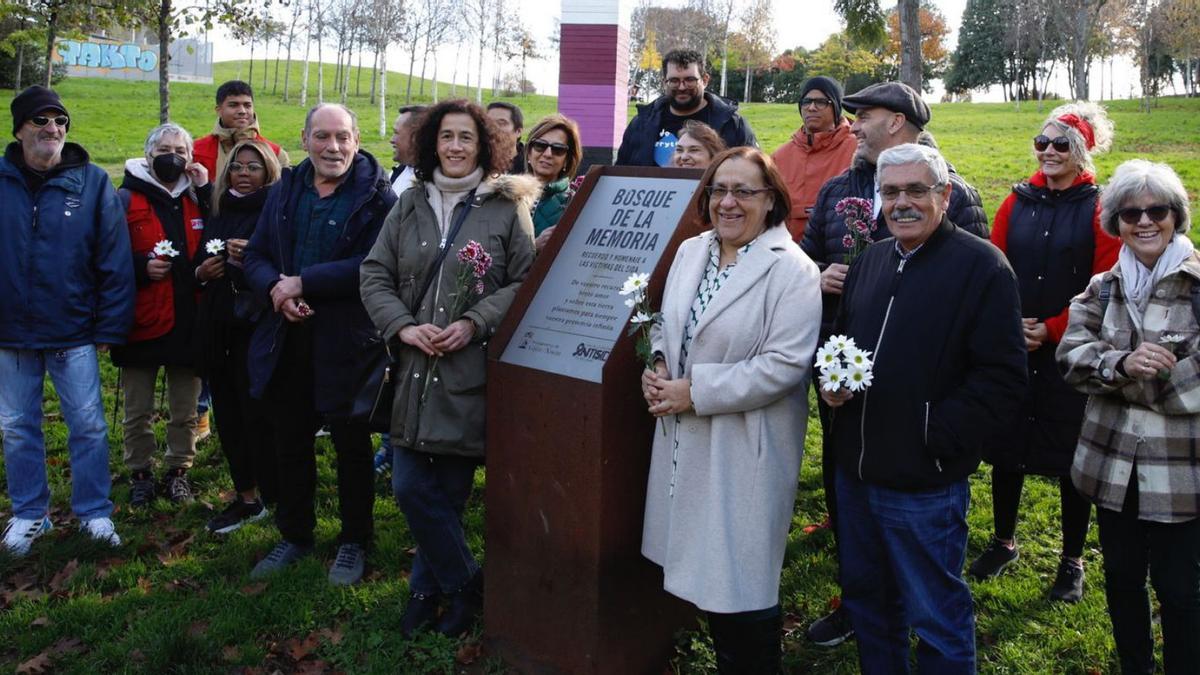 En el centro, Loli Fernández, Natalia González y Luis Manuel Flórez, ayer, junto a la placa conmemorativa de los fallecidos por sida en Asturias, en el parque de Los Pericones de Gijón. | Ángel González