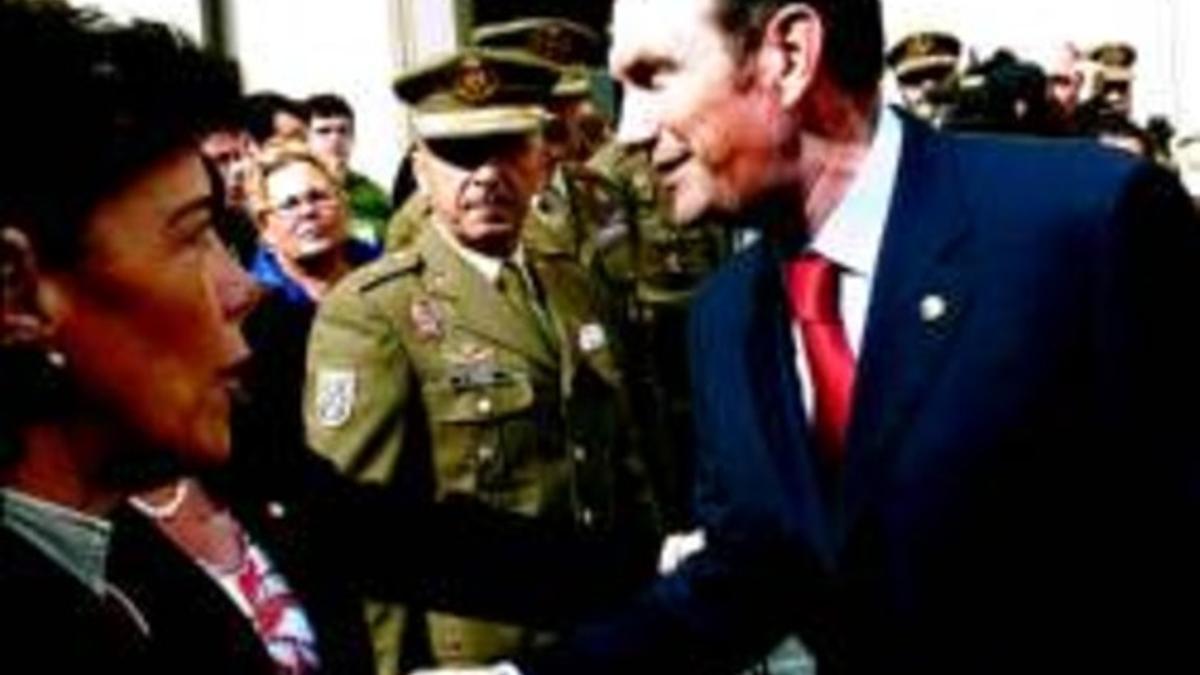 Ibarretxe saluda, tras el homenaje del Parlamento vasco al brigada asesinado, a una asistente al acto, en presencia de la socialista Isabel Cela (en primer término) y la delegación militar que representó al Ejército.