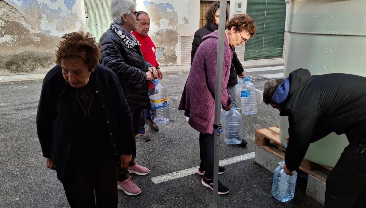 Los vecinos han llenado garrafas en el depósito que ha llenado un camión cuba