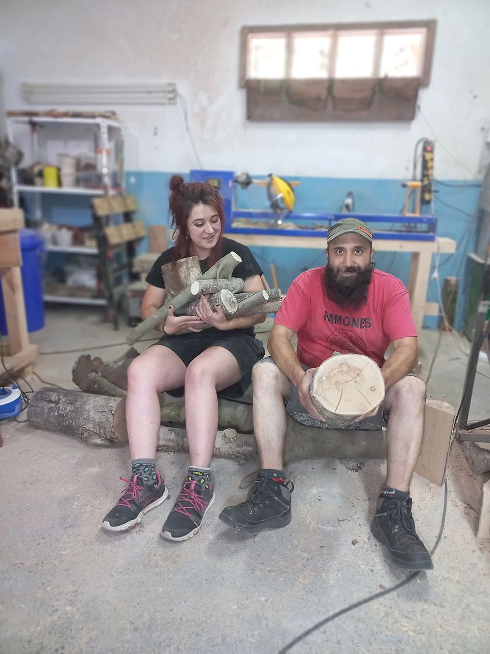 Sarah y Lalo en su taller con una de sus ingeniosas lámparas y otros objetos que elaboran con madera usada: desde cabeceros de cama a estanterías o muebles.