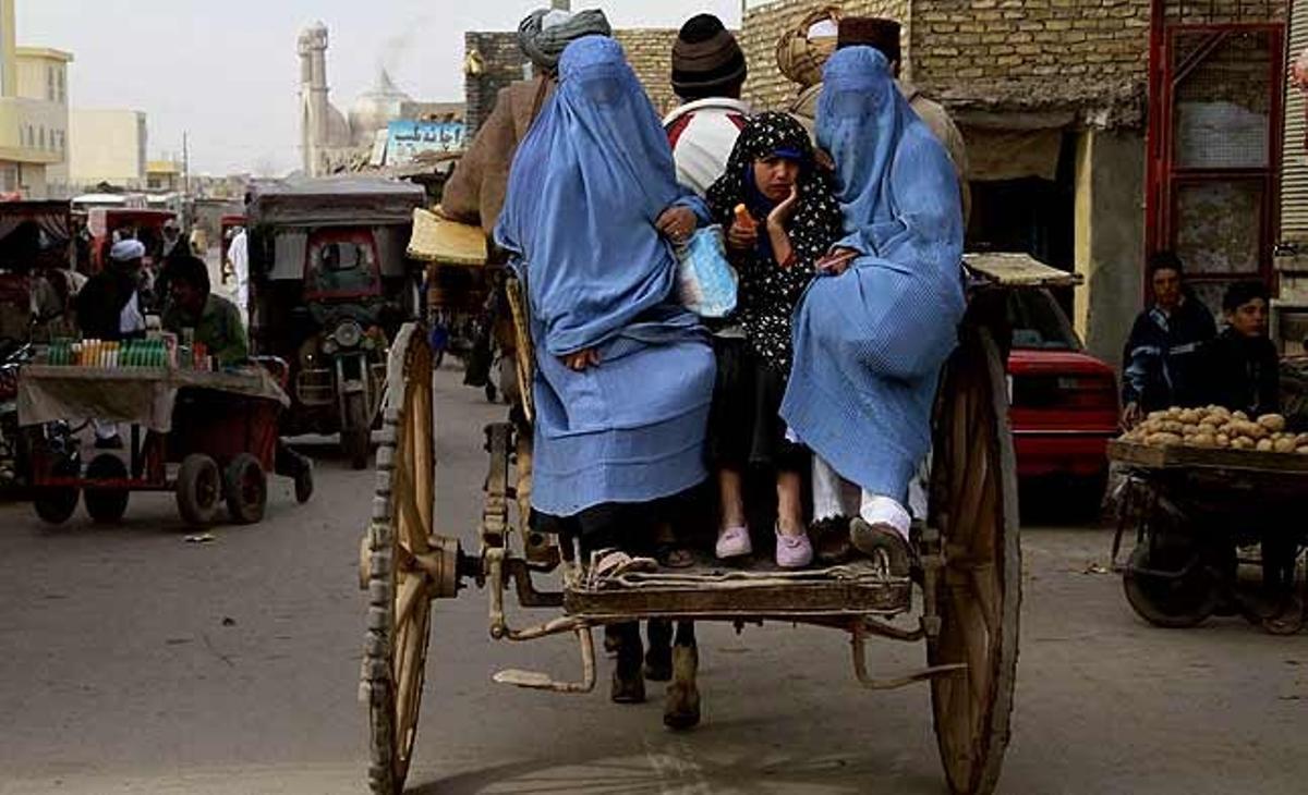 Dues dones i una nena viatgen en un carromato pels carrers de Herat (Afganistan). Malgrat el progrés dels últims anys, l’economia afganesa continua depenent de països estrangers i del comerç amb els països veïns.
