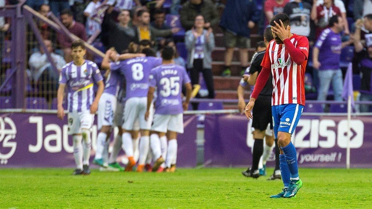 El defensa del Sporting de Gijon, Juan Rodríguez se lamenta ante la celebracion de uno de los goles conseguido por el Real Valladolid semifinales de los playoff