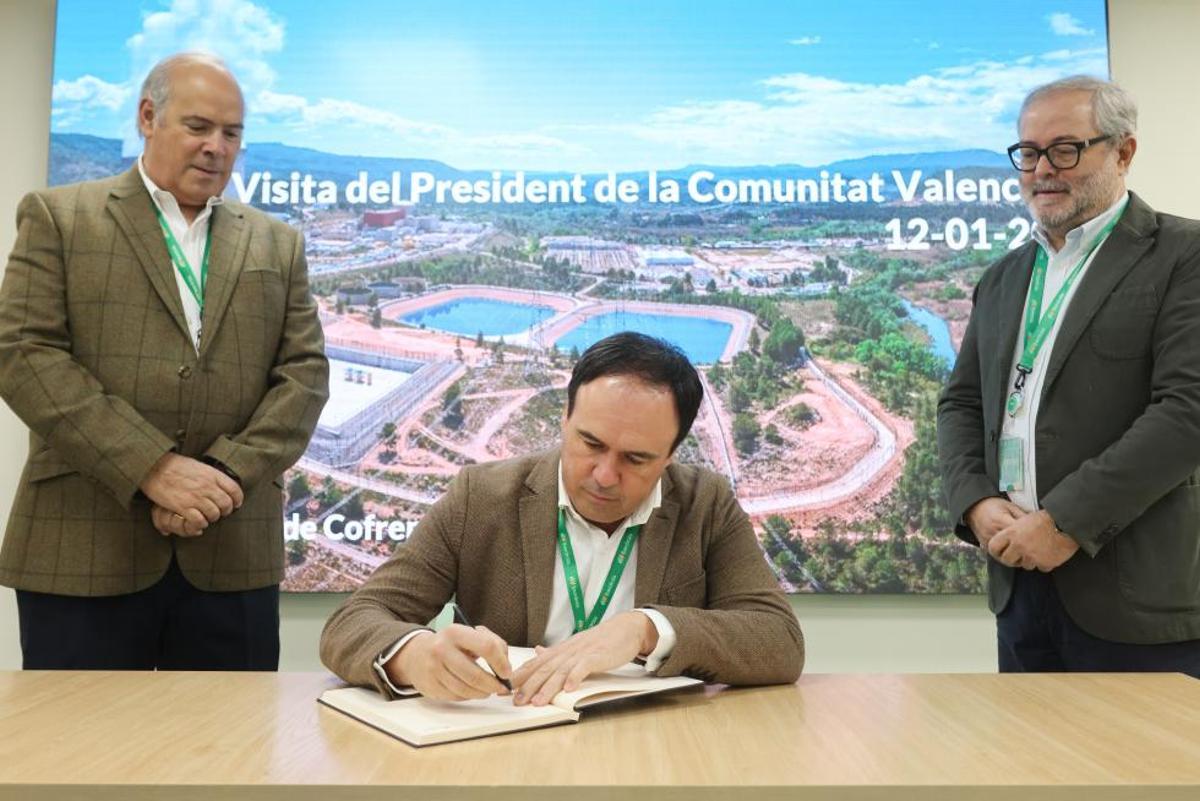 El jefe del Consell, Juanfran Pérez Llorca, firma en el libro de visitas de Cofrentes, ante el consejero delegado de Iberdrola España, Mario Ruiz-Tagle.