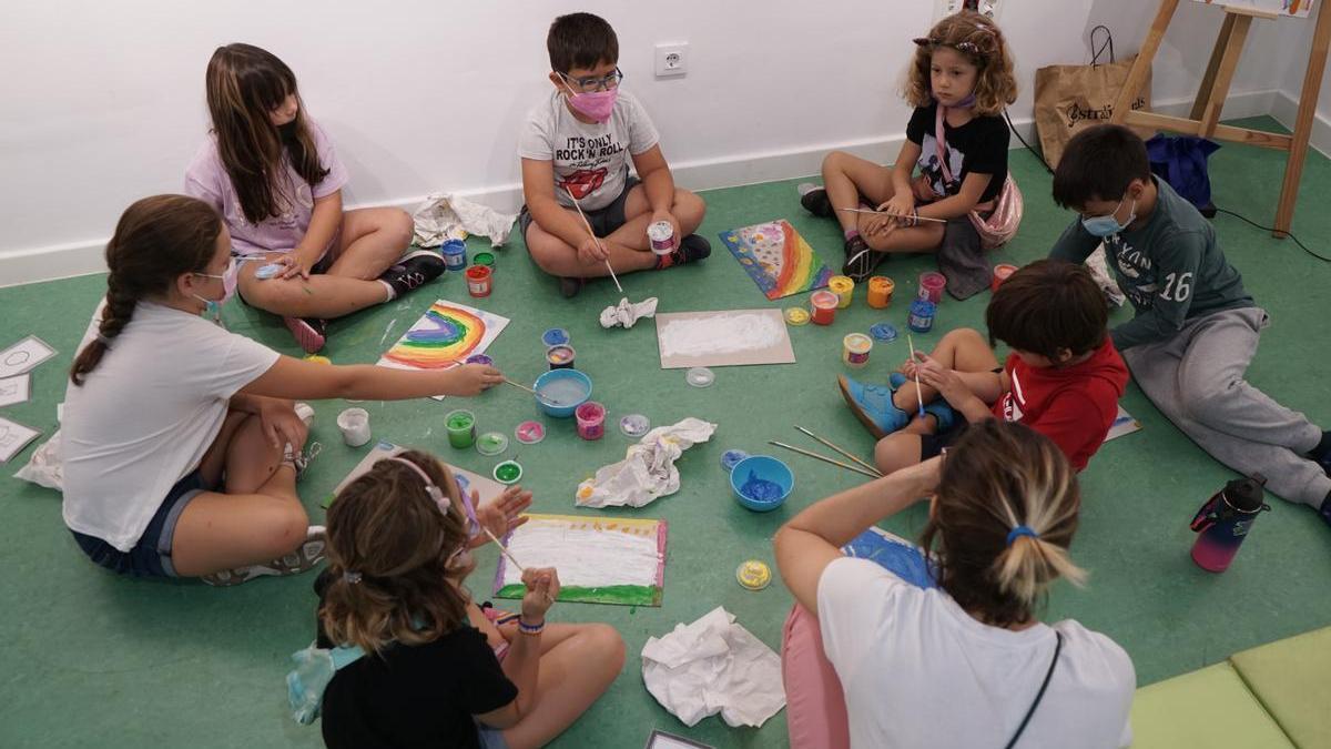 Un grupo de niños pinta láminas con los colores del arcoíris como protagonistas.