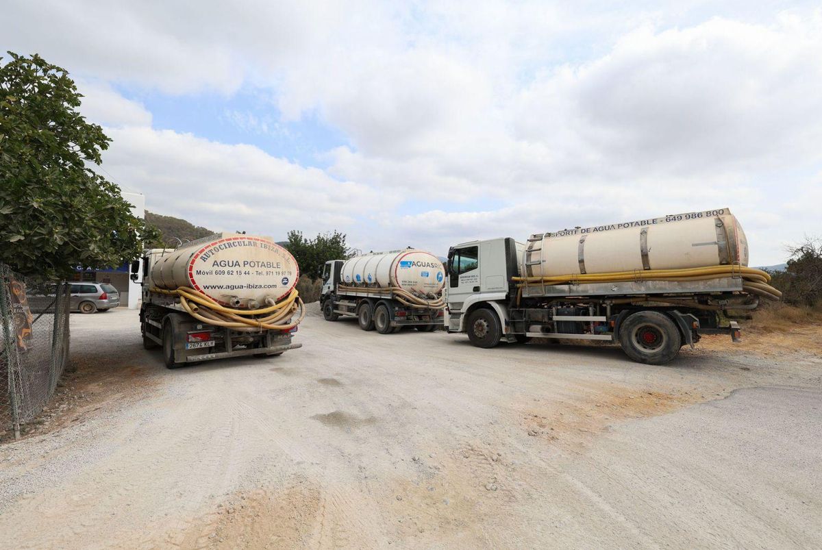 Varios camiones de transporte de agua potable esperan para cargar en un pozo. | TONI ESCOBAR