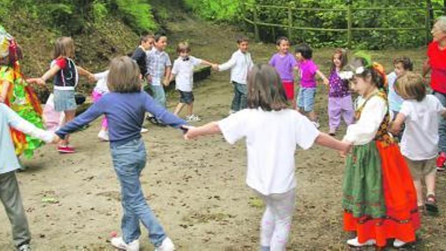 A la izquierda, los alumnos de la escuela, durante la danza prima. Los protagonistas del desencantamiento, a la derecha, cuando los galanes lanzan el bollo, ayer, en Guimarán.