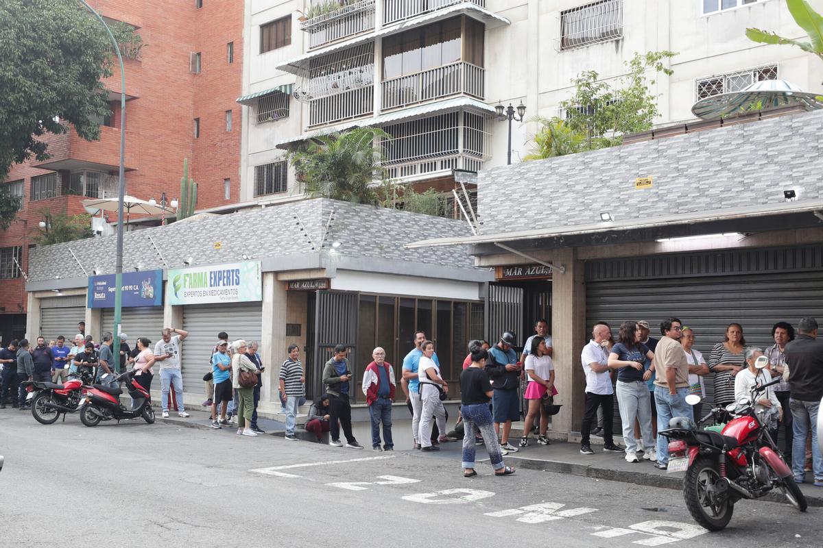 Ciutadans veneçolans desafien el toc de queda per fer cua a supermercats i farmàcies