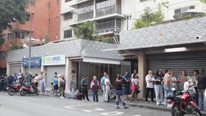 Ciutadans veneçolans desafien el toc de queda per fer cua a supermercats i farmàcies