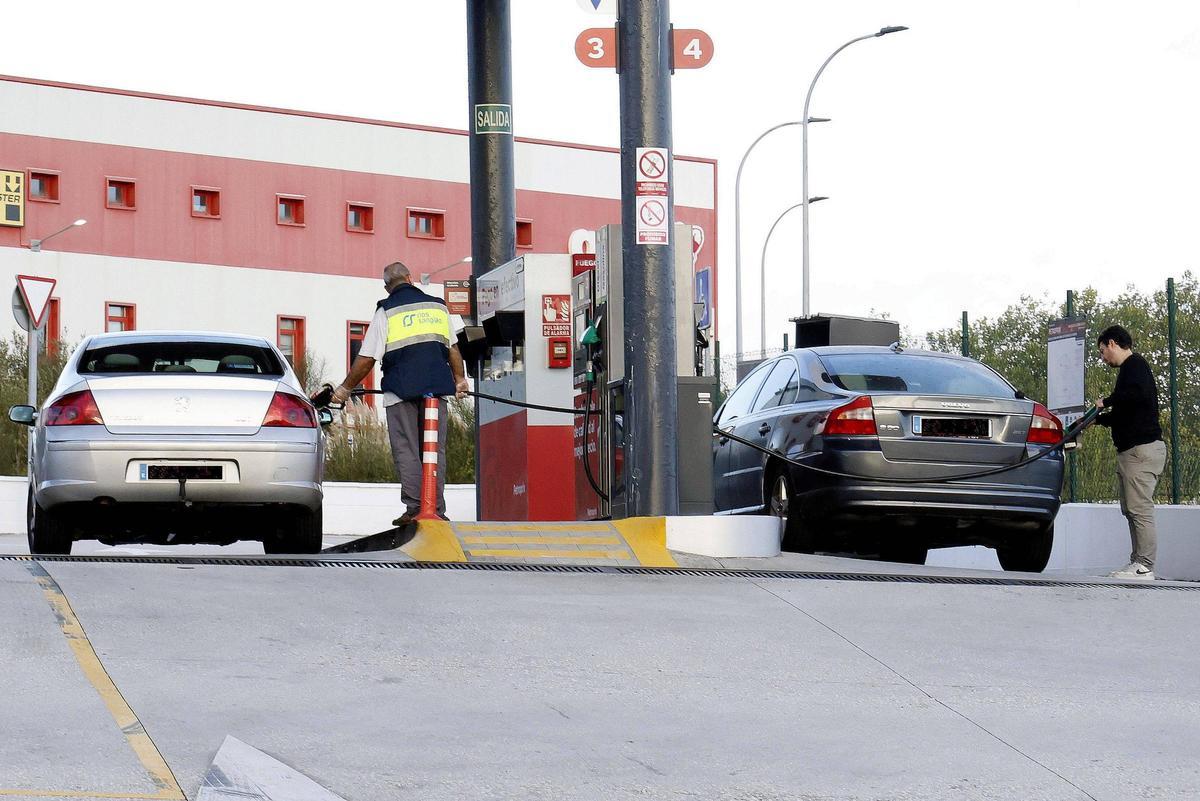 Un trabajador y una persona repostando en una gasolinera de Santiago.
