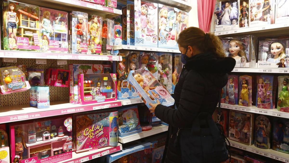 Una mujer ojea juguetes en una tienda de Zaragoza un mes y medio antes de la Navidad. | ANDREEA VORNICU