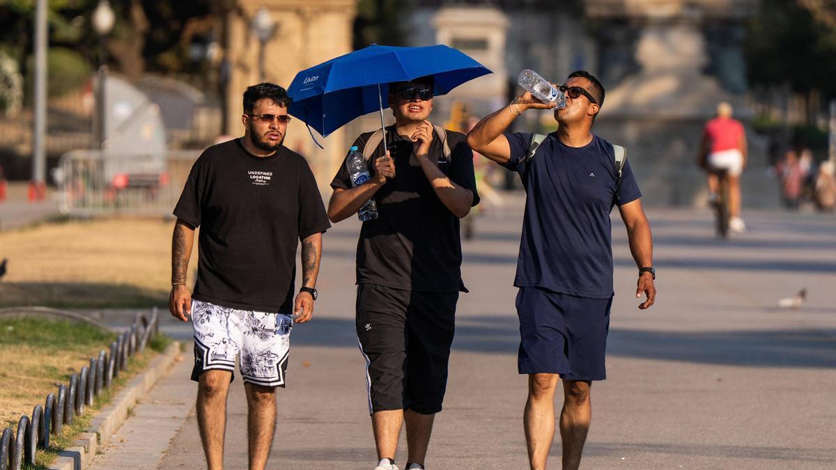 Tres joves passejant per Barcelona durant un dia de calor extrema