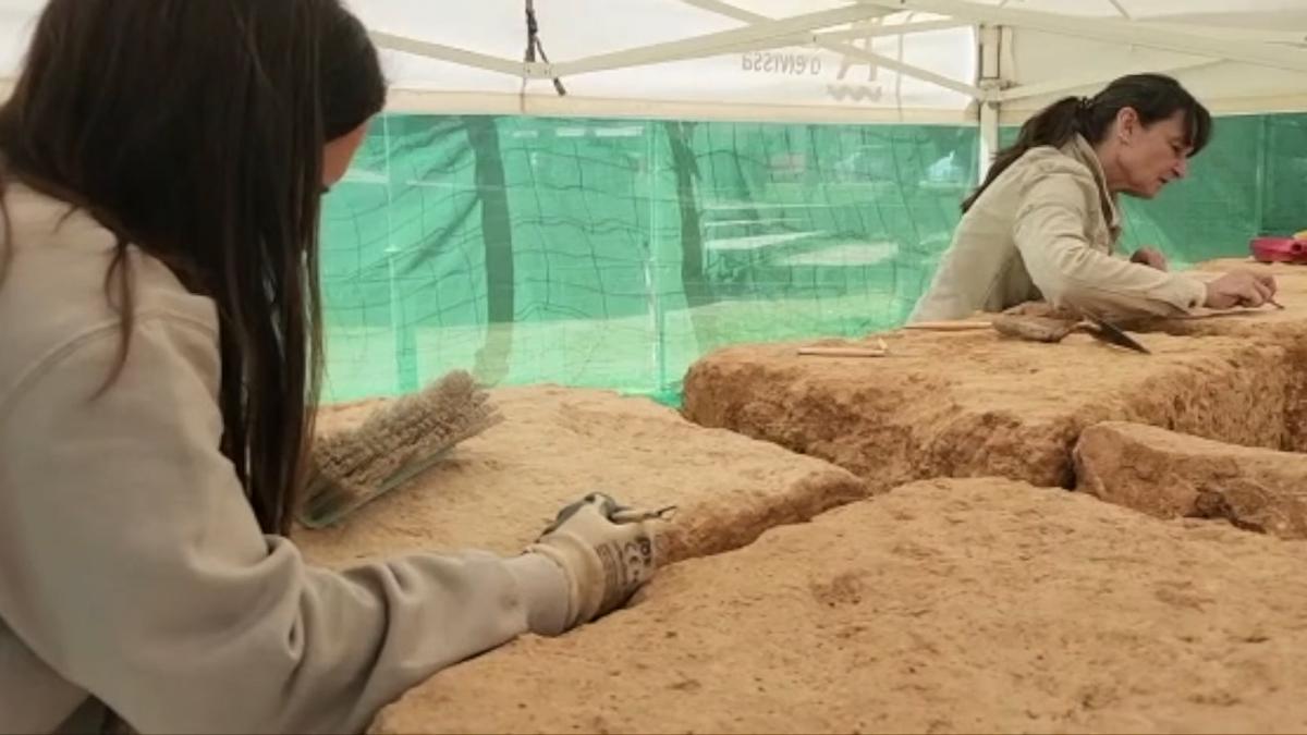 Un equipo de tres arqueólogas y una restauradora limpian la tierra acumulada durante dos mil años en los sillares del monumento funerario