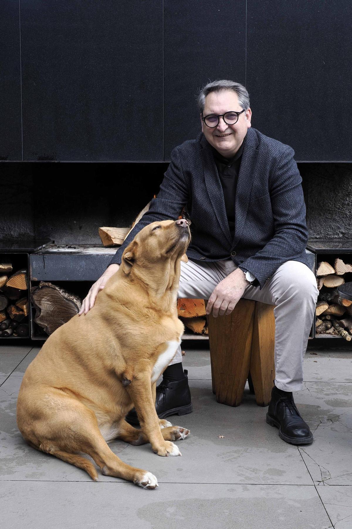 Joan Juncà amb la seva gossa Nina a la terrassa de Ca l'Enric, a la Vall de Bianya.