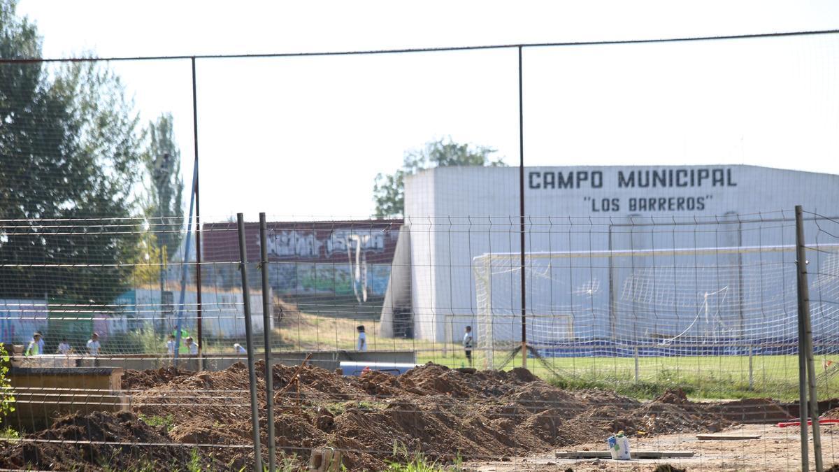 Vallado del proyecto en obras del futuro edificio de usos múltiples en Villaralbo con el campo municipal al fondo.
