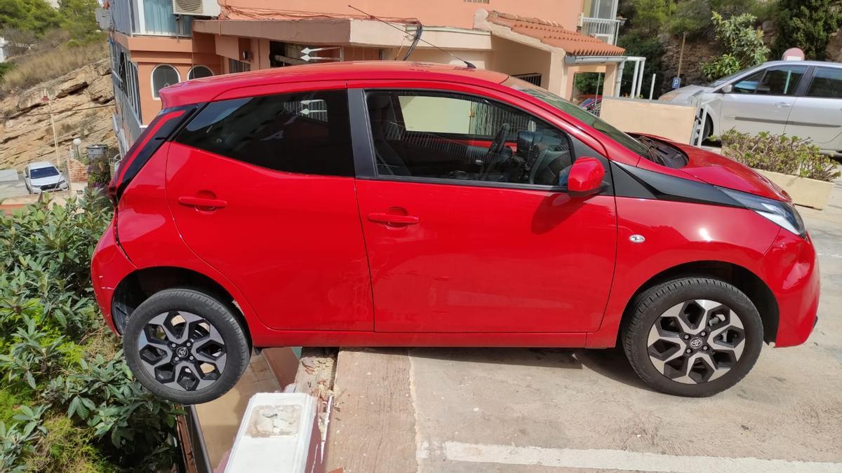 Un vehículo colisiona contra el muro de un edificio en Benidorm y queda suspendido en el aire