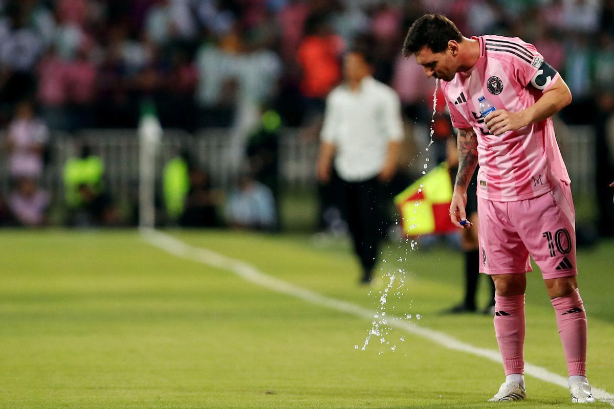 Lionel Messi escupe agua durante un partido